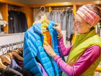 Frau kauft Wanderbekleidung im Fachgeschäft