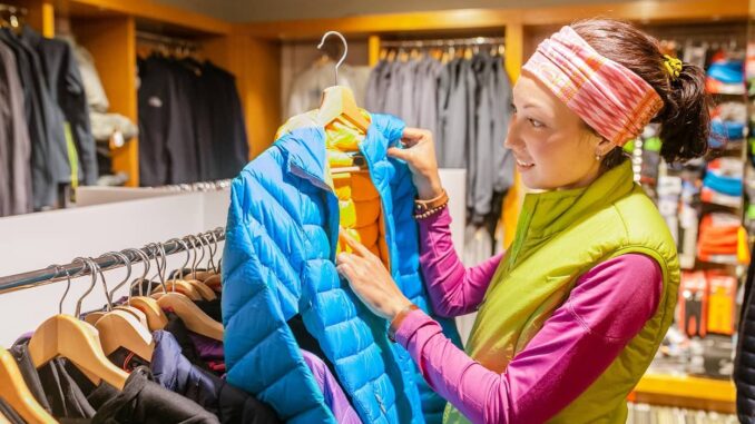 Frau kauft Wanderbekleidung im Fachgeschäft